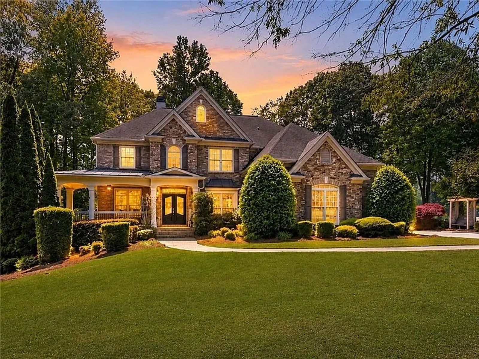 Stone residence with landscaped grounds photographed at twilight