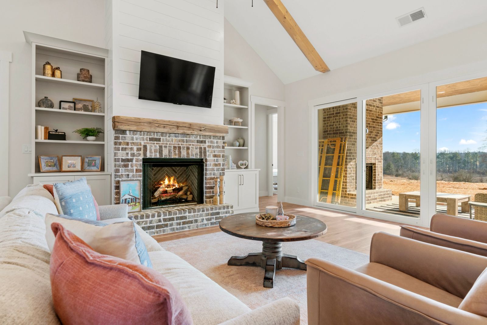 Living room with a stone fireplace, custom built-ins and expansive glazing